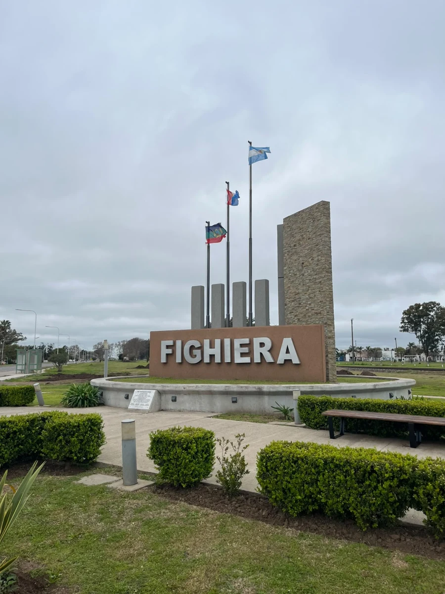Monumento de ingreso a Fighiera con las banderas de Argentina y Santa Fe